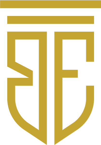 Monogramma dorato composto dalle lettere B ed E intrecciate con linee geometriche e una barra superiore.